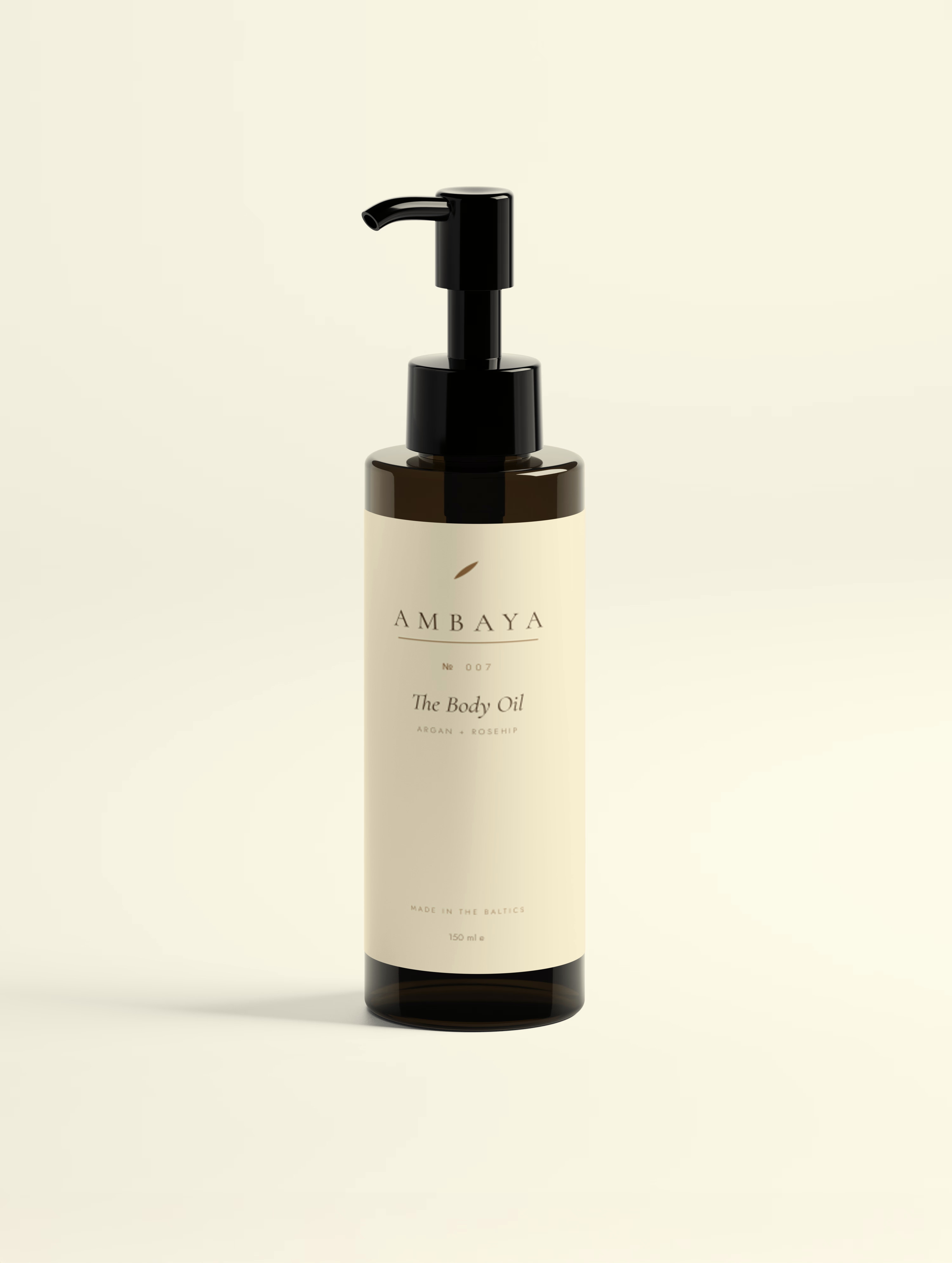 Amber glass bottle of The Body Oil, 150 ml, with a black pump and cream label carrying the gold AMBAYA wordmark, on a pale cream background.